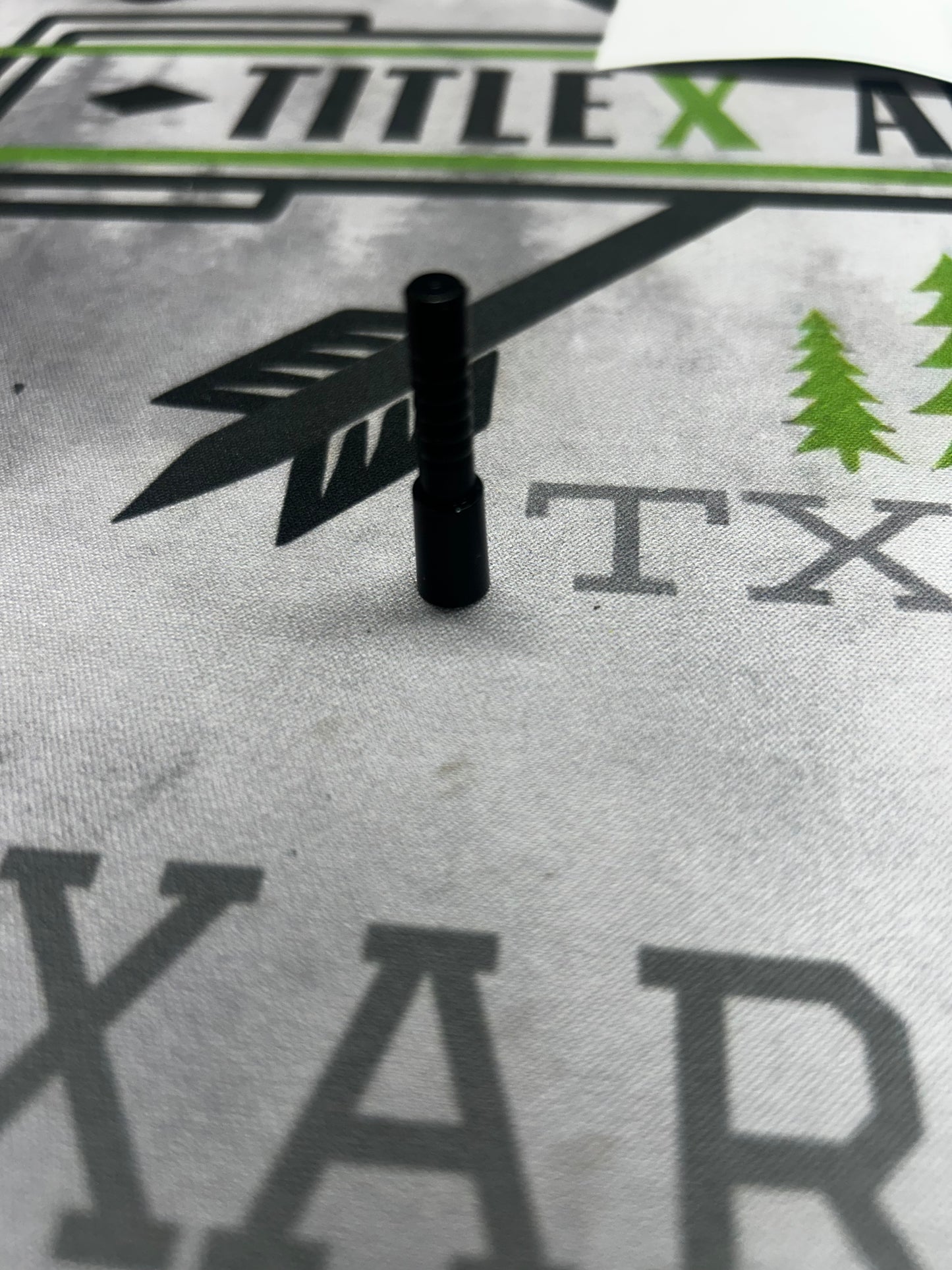 Black aluminum half-out projectile, 20 grain .204, resting on a printed surface.