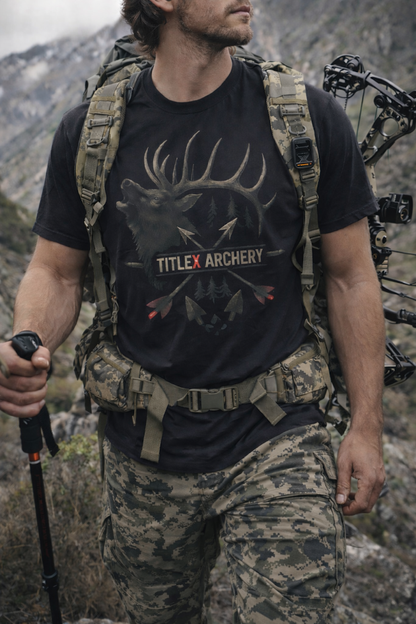 Man wearing a black TitleX Archery swag t-shirt featuring a bull elk graphic, outdoors.