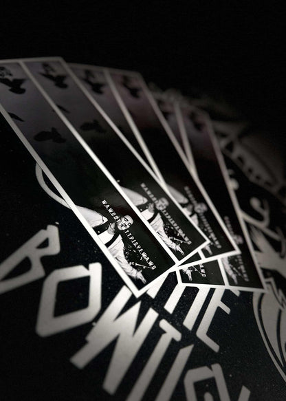 Black arrow-shaped wraps featuring white, stylized graphic designs, displayed on a dark background.