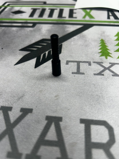 Black aluminum half-out projectile, 20 grain .204, resting on a printed surface.