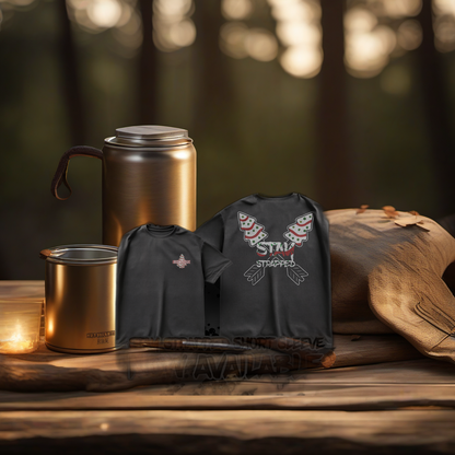 Stay Strapped tee displayed with camping gear on a rustic wooden table at golden hour. | titlex-scene-fathers-day